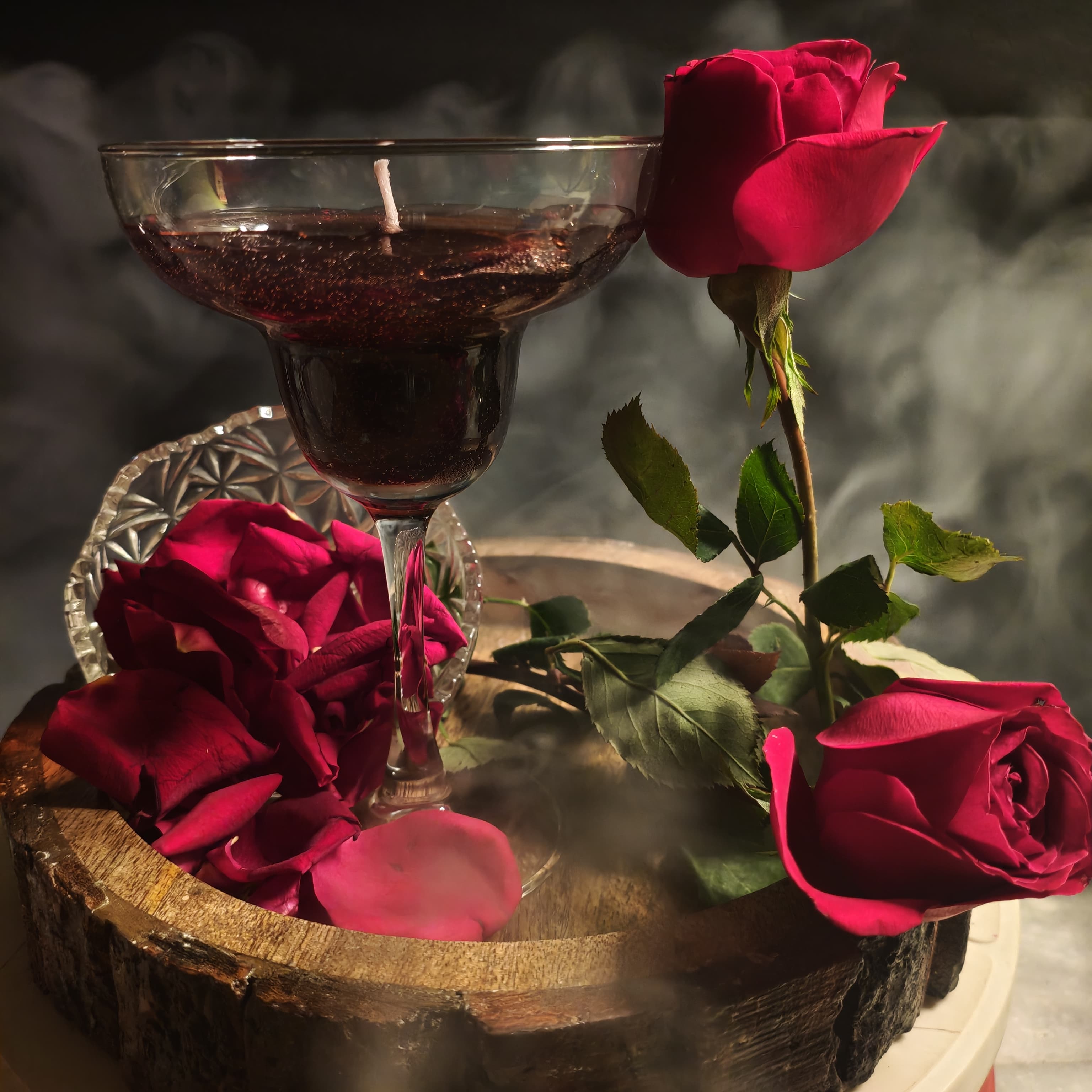 Rose styled candle in glass with red rose petals